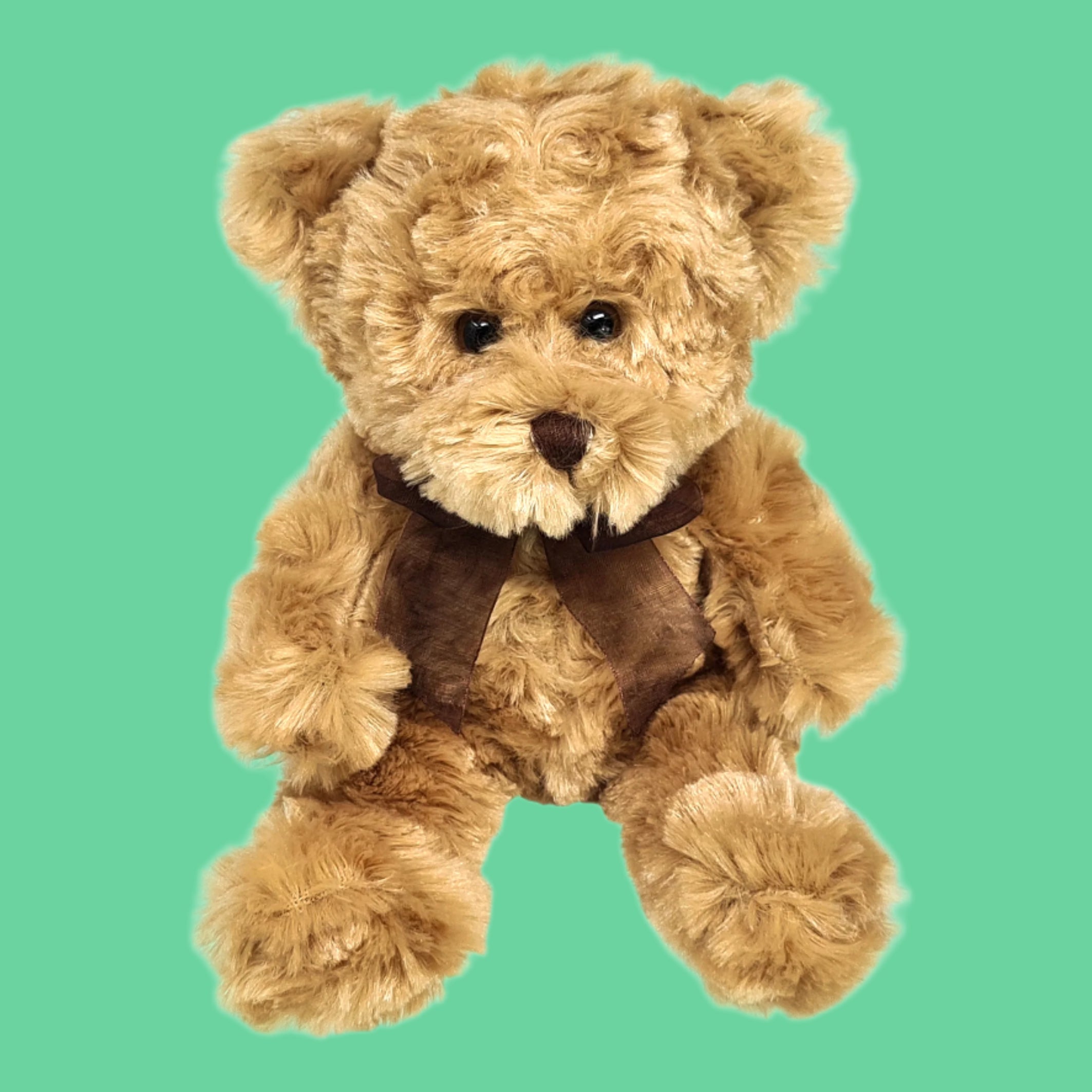 A small brown teddy bear with a bow around its neck.