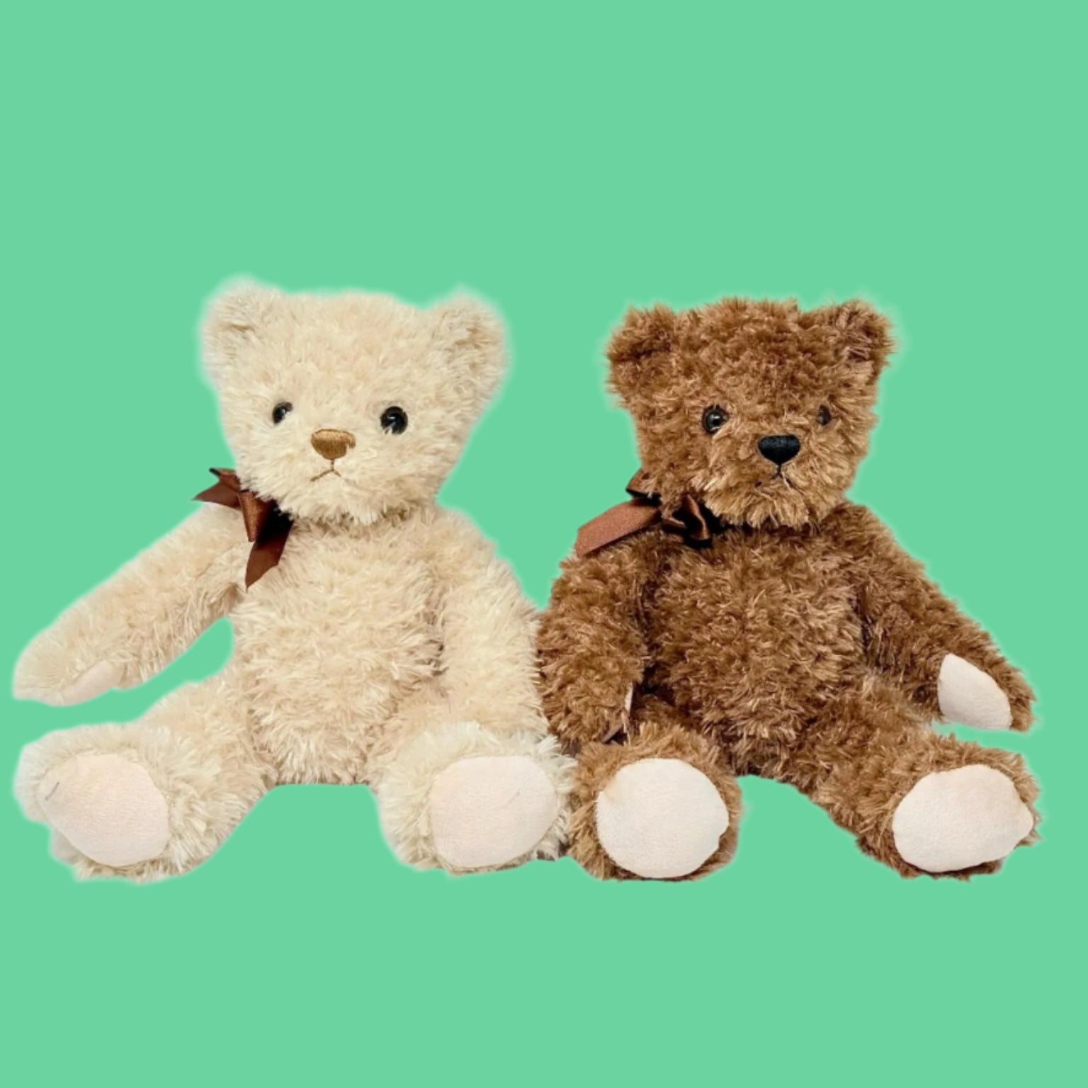 Two plush teddy bears, one light beige and one dark brown, sitting upright with bows around their necks.