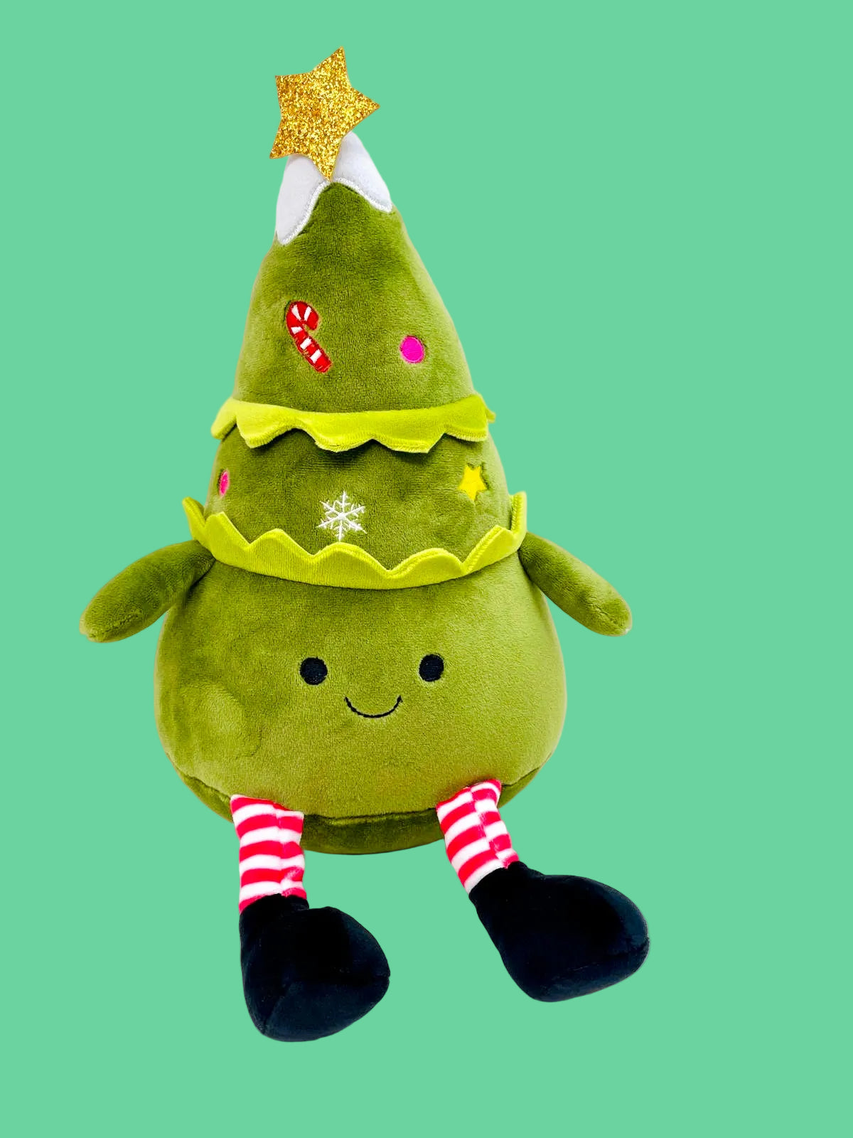 Green plush toy shaped like a Christmas tree with a star on a white background
